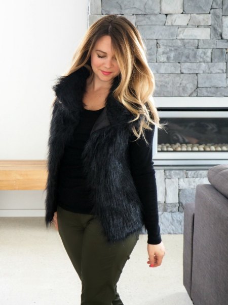 black long-sleeved t-shirt with bucket neck with fur vest and gray slim fit jeans