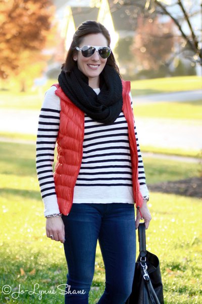 orange down vest with black infinity scarf and striped sweater