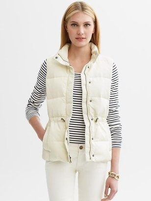 white down vest with striped t-shirt and slim jeans
