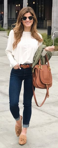white long sleeve blouse with dark blue cuffed skinny jeans and tan loafers