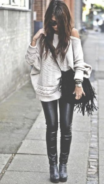light pink sweater with a shoulder with black leather sticks
