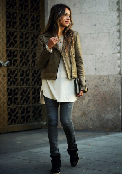 brown leather bike jacket with white tunic top and gray jeans