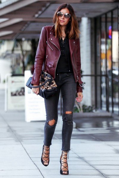 burgundy-colored leatherette jacket with darkly torn skinny jeans