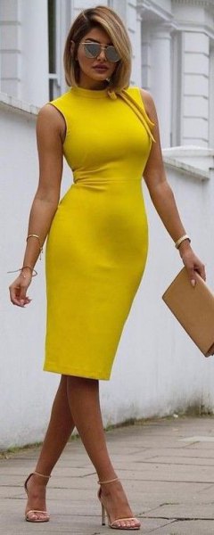 sleeveless, form-fitting, yellow midi dress with mock neck and mustard clutch
