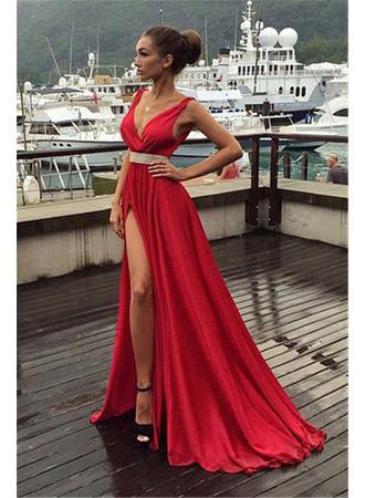 red floor-length dress with a high slit and belt and black heels
