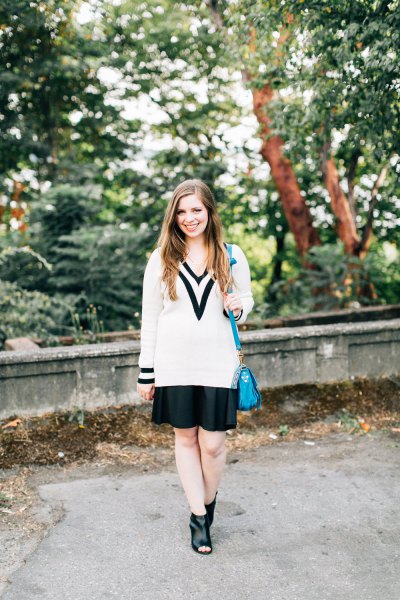 white and black chunky sweater with v-neck and mini pleated skirt