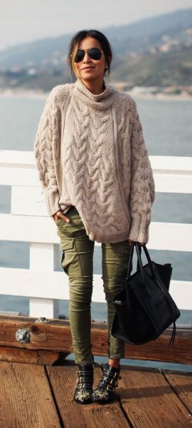 Light pink, oversized cable knit sweater with green, thin cargo jeans