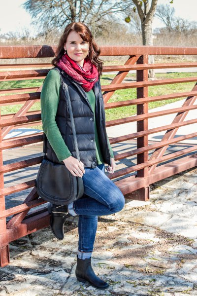 green sweater with a waterfall neckline and black quilted vest