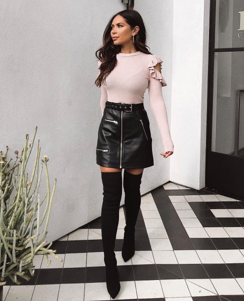 Light pink, cozy, figure-hugging sweater with black leather mini skirt with zip