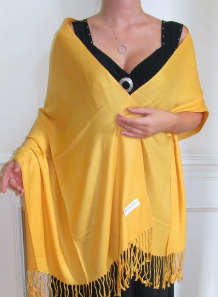 Lemon yellow fringed scarf with a black midi dress with a deep V-neck