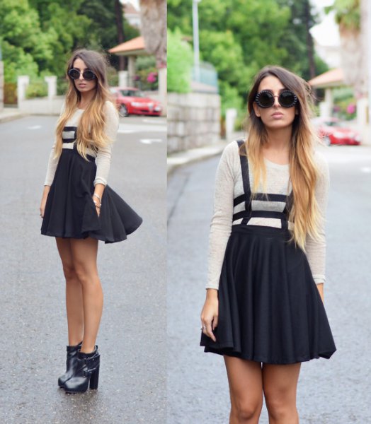 white long-sleeved T-shirt with black mini pleated skirt and boots with ankle heel