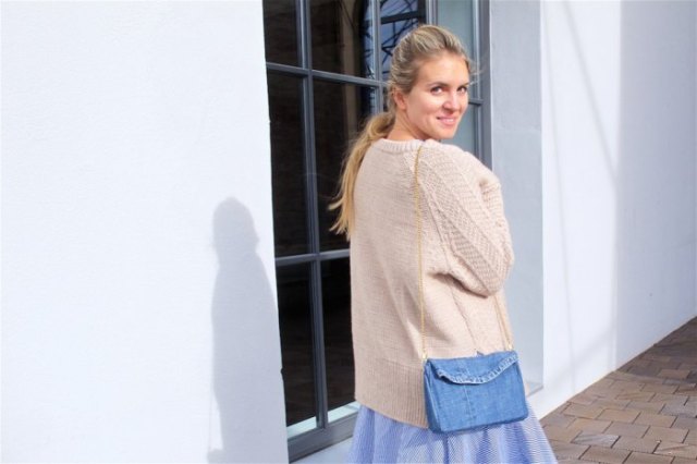 Ivory cardigan with a light blue flared midi skirt and a shoulder bag made of denim