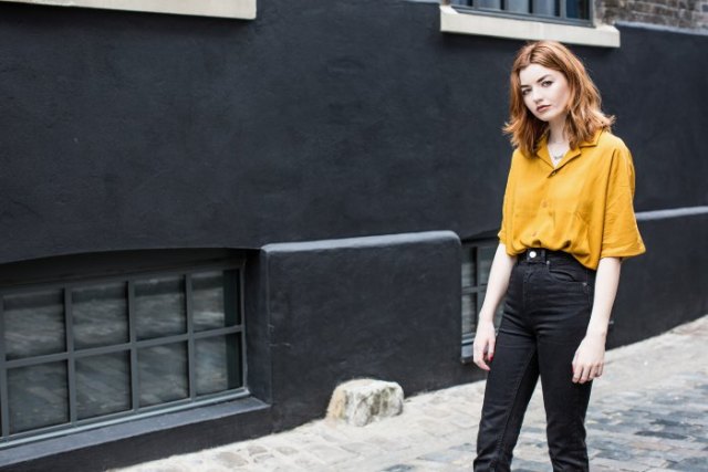 Mustard-colored shirt with wide sleeves and black high-rise jeans