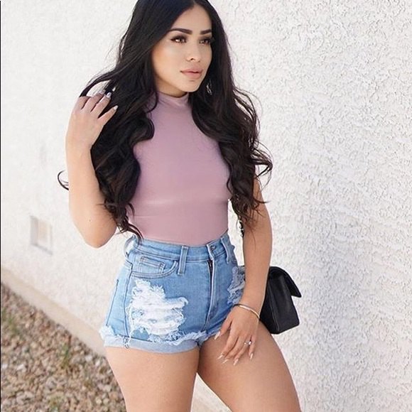 pink, form-fitting t-shirt with blue, high-waisted distressed shorts