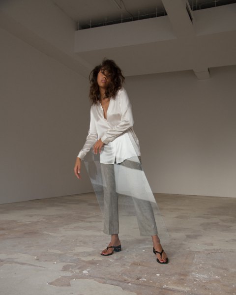 white oversized silk blouse with gray chinos with wide legs and black flip-flop heels