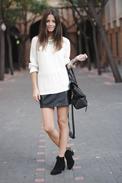 white cable knit sweater with black leather skirt and mini boots with heel