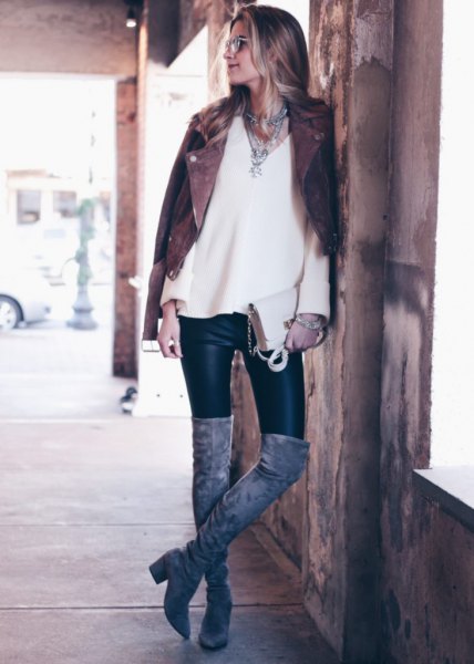 black biker jacket with white v-neck sweater and leather winter boots
