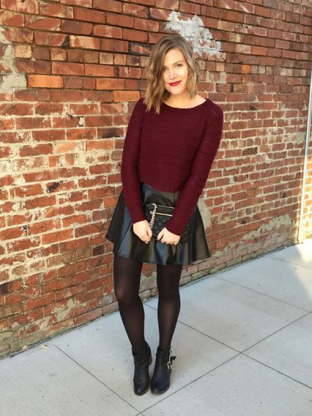 burgundy, figure-hugging knit sweater with black leather mini skirt and brown stockings