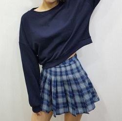 black cropped sweater with a boat neckline and checkered blue mini skirt