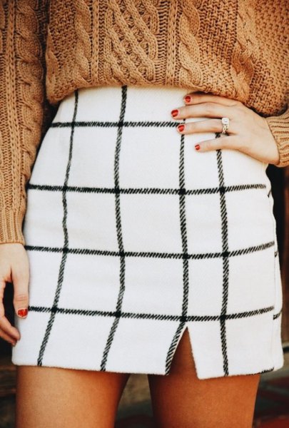white checkered mini skirt with a green, chunky sweater with cable cutout