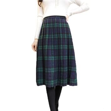 white long sleeve sweater with green and dark blue midi plaid skirt