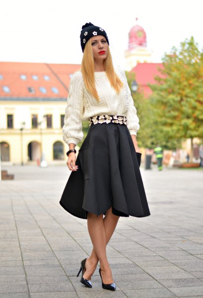 white, rough knitted sweater with black pleated skirt and heels