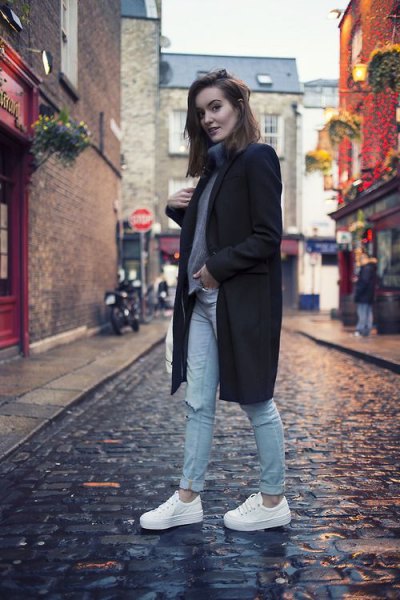 black long-line wool coat with gray sweater and white shoes