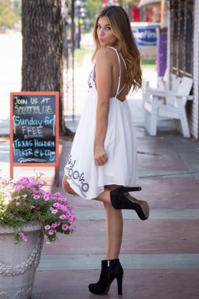 white midi babydoll dress with open back with black suede boots
