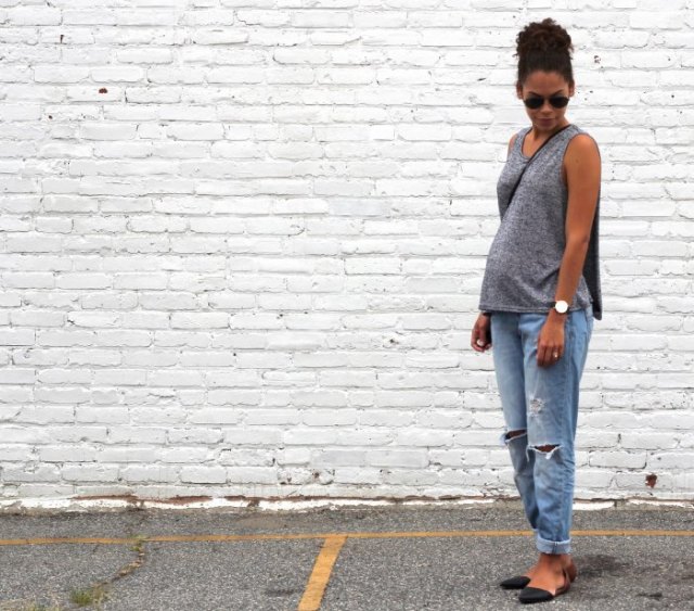 gray sleeveless sweater with bucket neck with relaxed fit light blue jeans