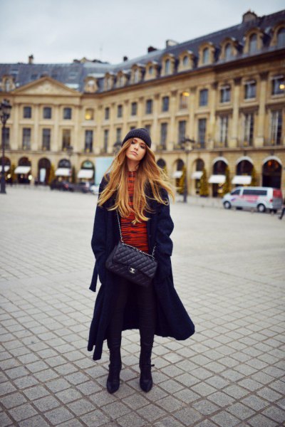 long black coat with orange shirt and knitted hat
