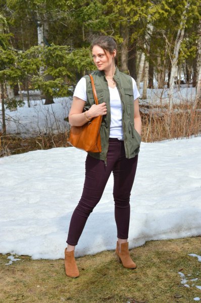 green work vest with white t-shirt and black slim jeans