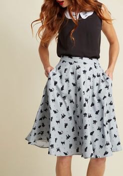 black sleeveless top with white printed midi-blown chiffon skirt with pockets