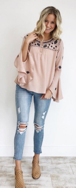 blush and black wide ruffle sleeve blouse with ripped and cropped jeans