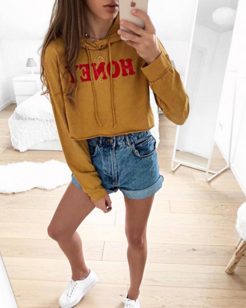 mustard yellow printed cropped hoodie with blue mini denim shorts