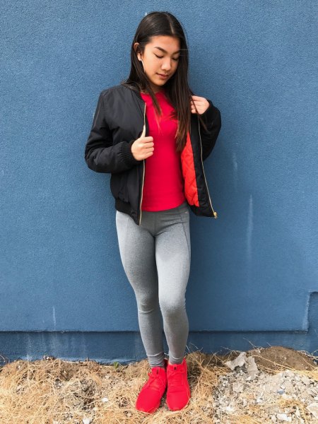red tee with black bomber jacket and gray leggings