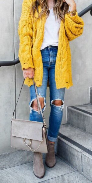 chunky cable knit yellow cardigan with ripped blue jeans