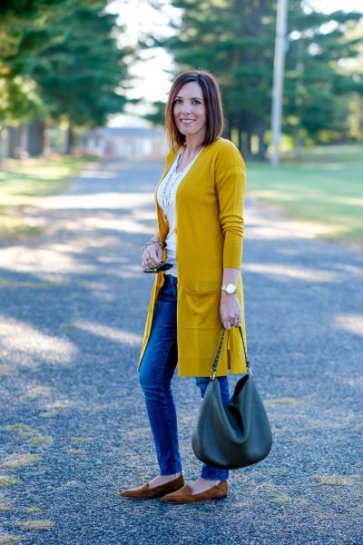 longline mustard yellow cardigan with white vest top and blue jeans