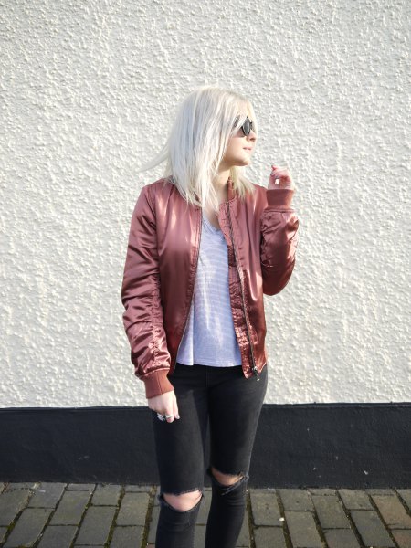 pink gold bomber jacket with striped tee and black ripped jeans