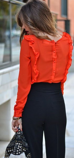 orange ruffle blouse with black chinos