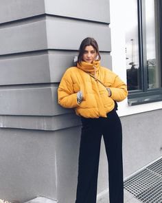 yellow puffer jacket with black jeans with wide legs