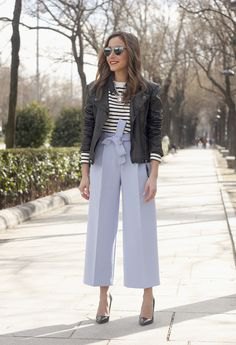 black bomber jacket with black and white striped sweater and wide leg blue trousers
