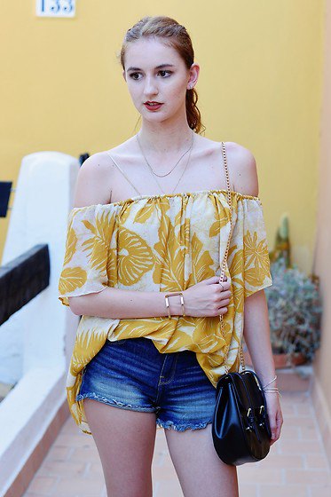 gold and white printed off the shoulder blouse with blue denim shorts
