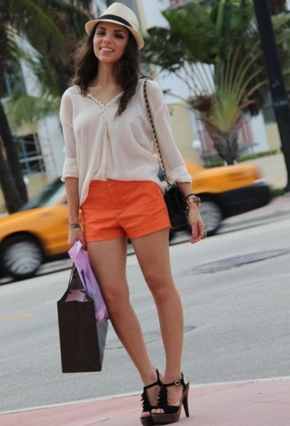 white blouse with straw hat and orange mini shorts