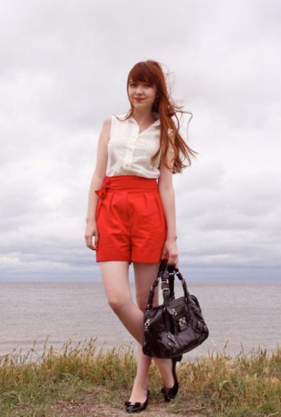 white sleeveless chiffon blouse with orange high-height pleated shorts