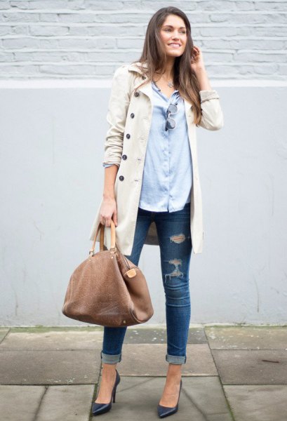 beige long jacket with light blue shirt and ripped skinny jeans