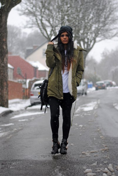 green fur lined parka jacket with white print tee and black mini shorts