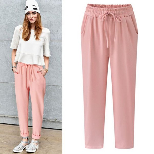 white chiffon top with half-heated hem with light pink elasticated trousers at the waist