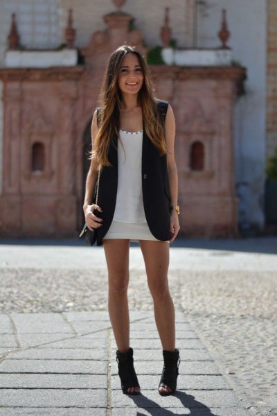 black sleeveless blazer with white mini dress