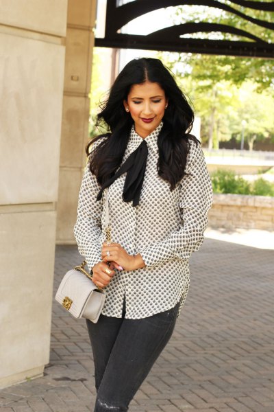 white and black patterned tie neck blouse gray jeans