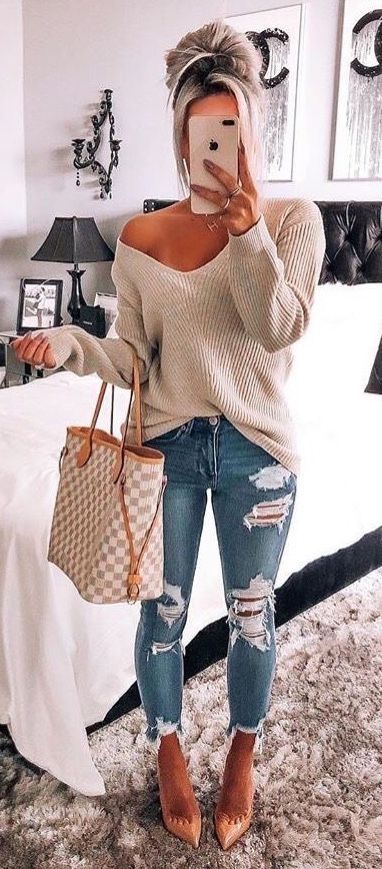 Cute off the shoulder knit sweater with trendy distressed denim .